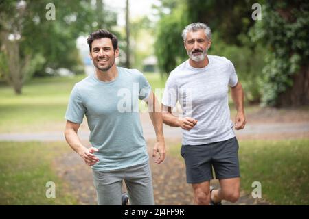 hommes ou amis de sexe masculin courant à l'extérieur Banque D'Images