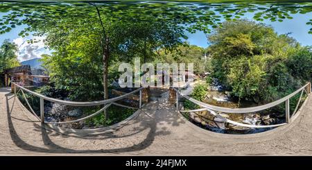 Vue panoramique à 360° de BATUMI, GÉORGIE - SEPTEMBRE 2021: Full Seamauon 360 hdri sur pont en métal au-dessus de la rivière rapide dans les montagnes avec beaucoup de touristes en équirectang