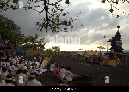 Purifier les esprits: Les membres d'une famille balinaise se préparent à commencer un rituel dans un temple de bord de mer à Klungkung regency, Bali, Indonésie. Banque D'Images