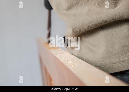 Menuisier travaillant sur la machine de découpe du bois pendant la fabrication de meubles de porte en bois dans une nouvelle maison Banque D'Images