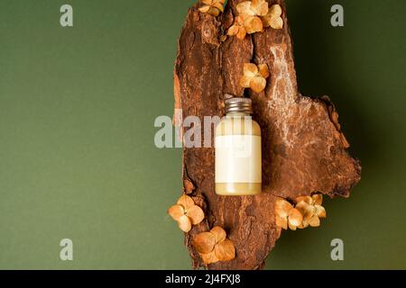 Une bouteille cosmétique en verre ambré avec laque blanche sur fond de bois avec fleurs. Gros plan, espace publicitaire. Concept de traitement de salon, pack de marque minimalisme Banque D'Images