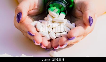 Médecin avec des pilules en main. Vue de dessus de la pile de pilules blanches dans les mains des femmes. Banque D'Images