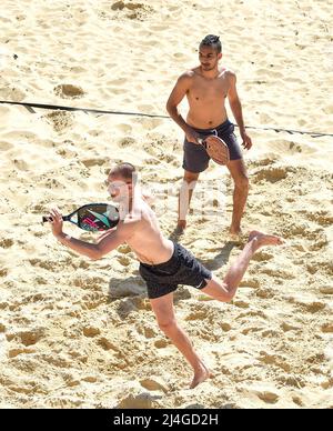 Brighton UK 15th avril 2022 - ces joueurs de tennis de plage profitent du soleil chaud à Brighton avec des températures qui devraient atteindre plus de 20 degrés dans certaines parties du Royaume-Uni : Credit Simon Dack / Alay Live News Banque D'Images