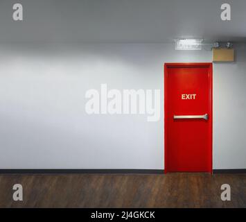 Porte de sortie de secours. Porte de secours de sortie de secours en métal de couleur rouge avec alarme et lumière d'urgence et équipement d'extinction d'incendie sur le mur du bâtiment pour sa Banque D'Images