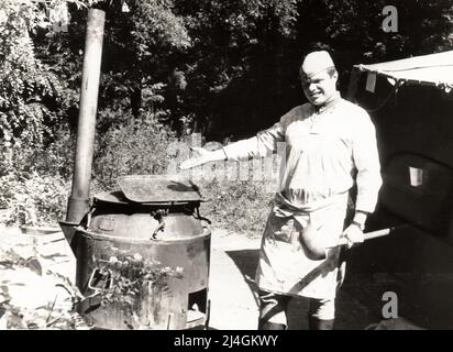 Village de Trekhizbenka, région de Luhansk, URSS - vers 1982 : photo d'un jeune cadet en uniforme militaire en service dans la cuisine de campagne. Banque D'Images