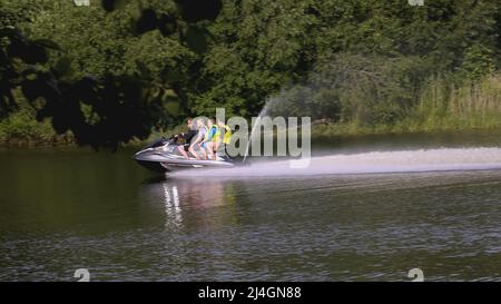 UKRAINE, KIEV - 17 MARS 2022 : les gens font un tour en bateau dans un étang. CRÉATIF. La famille se déplace sur un bateau de plaisance dans la rivière. Les parents avec enfants passent Banque D'Images