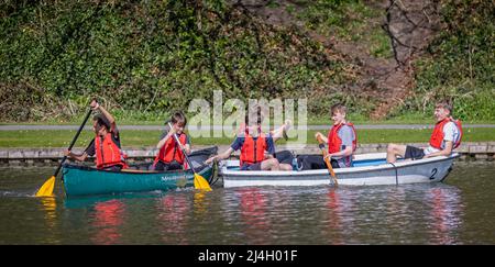 Groupe de jeunes garçons multiraciaux qui s'amusent dans un canot et un bateau à rames sur le lac de Warminster à Warminster, Wiltshire, Royaume-Uni, le 15 avril 2022 Banque D'Images