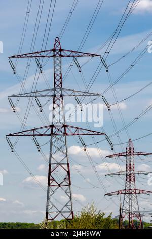 Pylônes métalliques transportant des câbles électriques aériens de lignes haute tension. Concepts de réseaux de transmission électrique, d'approvisionnement en énergie, de consommation d'énergie Banque D'Images