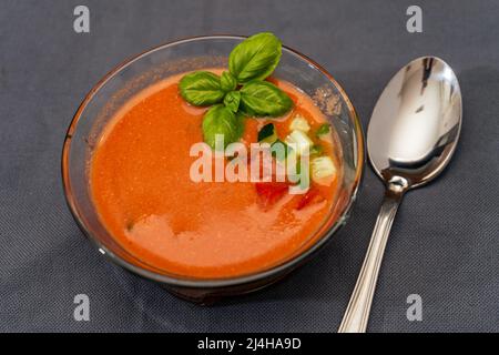 Bol en verre transparent avec gaspacho andalou, tomates, concombres et autres légumes. Soupe de légumes bio ou boisson froide à boire en été ou Banque D'Images