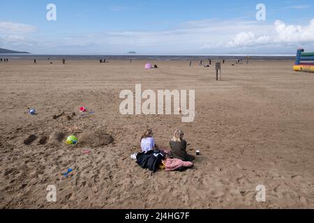 Les vacanciers apprécient la plage de Weston Super Mare avec le Grand Pier dans le Bristol Chanel, Somerset. Banque D'Images