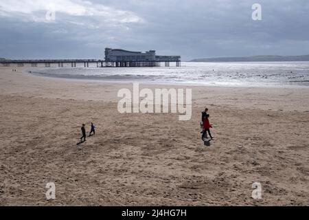 Les vacanciers apprécient la plage de Weston Super Mare avec le Grand Pier dans le Bristol Chanel, Somerset. Banque D'Images