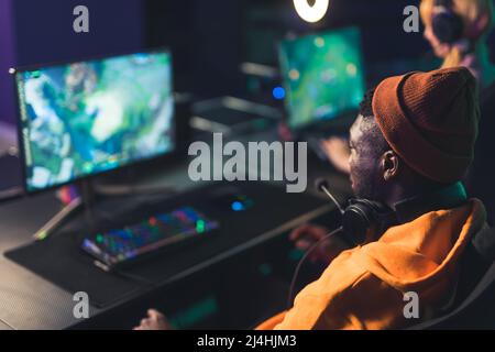 Jeune joueur concentré dans le casque jouant le jeu vidéo dans l'ordinateur intérieur eSport concept moyen de gros plan . Photo de haute qualité Banque D'Images