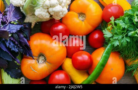 Fond coloré de légumes frais. Gros plan de légumes multicolores mûrs sur une table en bois Banque D'Images