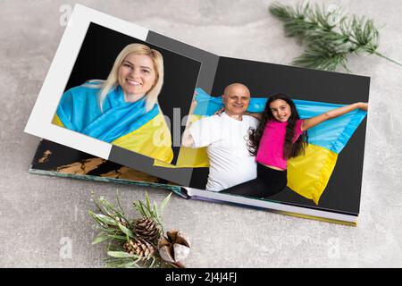 Archives photos de famille enregistrées dans un livre photo aux couleurs vives ; souvenirs d'été éclatants placés dans le livre photo. Famille avec drapeau de l'ukraine Banque D'Images