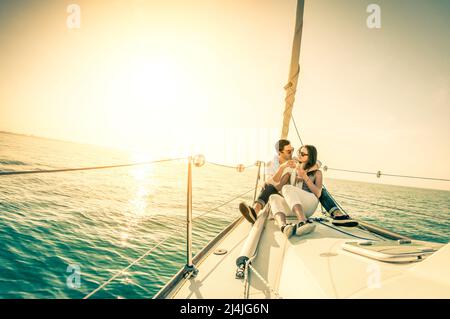 Jeune couple amoureux du bateau à voile avec champagne au coucher du soleil - concept exclusif de vie heureux - Soft focus en raison du rétroéclairage Banque D'Images