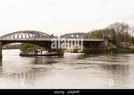 Un bateau de plaisance vide passant sous le pont Barnes sur la Tamise à Barnes, dans le sud-ouest de Londres, Angleterre, Royaume-Uni Banque D'Images