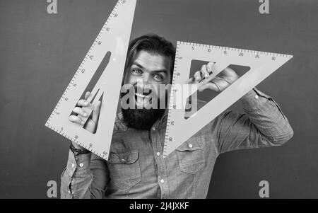 homme heureux avec la taille mesurée sur l'outil de mathématiques de règle de triangle, étude d'école Banque D'Images