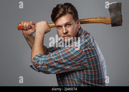 Portrait de l'homme barbu avec hache posant en studio Banque D'Images