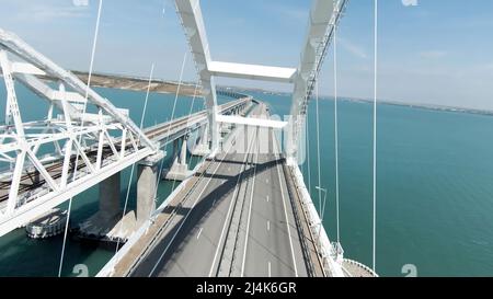 Immense pont. Vue de drone. Action. Un long pont sur l'océan sur lequel les voitures peuvent se déplacer librement, le pont est situé à côté des montagnes vertes Banque D'Images