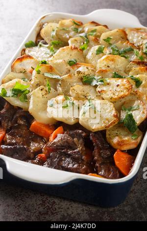 Le pot chaud du Lancashire est un agneau succulent dans une sauce à la viande, recouvert de pommes de terre tendres en dessous et croustillantes sur les gros plats dans le plat de cuisson du Banque D'Images