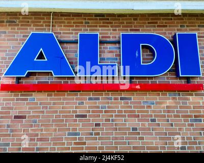 Neumuenster, Allemagne - 16. Avril 2022 : un grand logo bleu de la chaîne de rabais allemande Aldi sur un mur de briques Banque D'Images