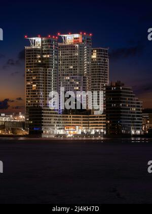 Helsinki / Finlande - 16 AVRIL 2022 : vue sur un quartier résidentiel moderne avec trois gratte-ciel. Des aurores boréaux éclairent le ciel Banque D'Images
