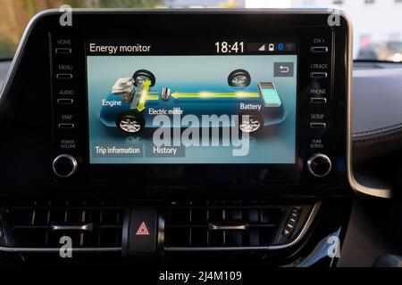 Écran d'une voiture hybride Toyota CH-R à autocharge à essence montrant l'interaction entre le moteur à combustion interne, le moteur électrique et la batterie Banque D'Images