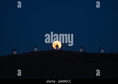 Consuegra, Espagne. 16th avril 2022. La pleine lune s'élève au-dessus d'un moulin à vent à Consuegra, Tolède. La pleine lune d'avril, également connue sous le nom de Lune rose, est cette année la première pleine lune de la saison de printemps, ce qui signifie que la pleine lune d'avril est aussi la pleine lune Pascal. Credit: Marcos del Mazo/Alay Live News Banque D'Images