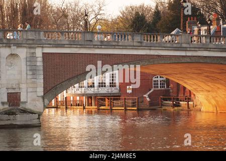 Vue sur le pont de Hampton court depuis la poupe d'un croiseur de rivière en regardant à travers l'une des arches dans la lumière du soleil du printemps soir Banque D'Images