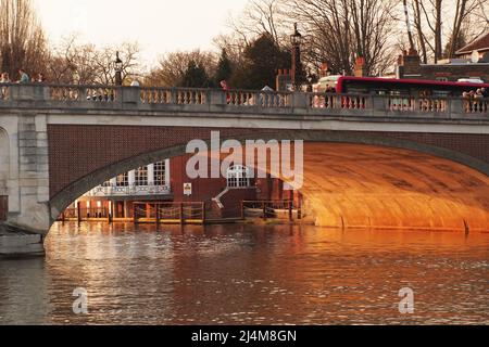 Vue sur le pont de Hampton court depuis la poupe d'un croiseur de rivière en regardant à travers l'une des arches dans la lumière du soleil du printemps soir Banque D'Images