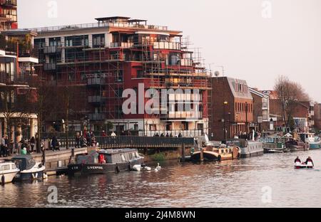 Une vue sur Kingston-upon-Thames depuis un bateau de croisière sur la Tamise montrant un chemin de rivière et de rive animé et des bâtiments au bord de l'eau Banque D'Images