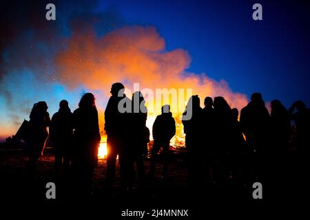 Norderney, Allemagne. 16th avril 2022. De nombreuses personnes se tiennent devant un feu de joie de Pâques sur la plage ouest de l'île le samedi Saint. Credit: Hauke-Christian Dittrich/dpa/Alay Live News Banque D'Images