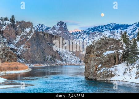 pleine lune s'élevant au-dessus de la rivière missouri et des falaises en hiver près de dearborn, montana Banque D'Images