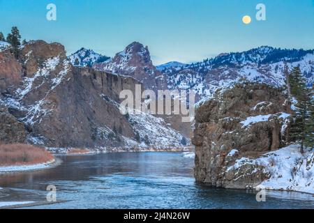 pleine lune s'élevant au-dessus de la rivière missouri et des falaises en hiver près de dearborn, montana Banque D'Images