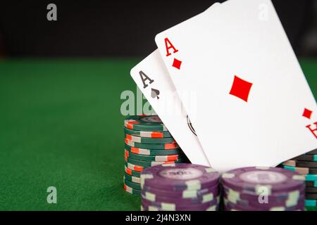 Deux as sont vus parmi des piles de jetons de poker. Banque D'Images
