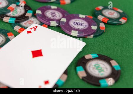 Un as de diamants se trouve sur une pile de jetons de poker. Banque D'Images