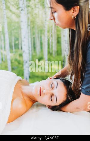 Femme thérapeute effectuant un massage du cou à une patiente inclinée de la tête. Détente et détente Banque D'Images