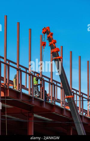 Les constructeurs fixent des poutres en fer avec une grue. Structure du châssis. Banque D'Images