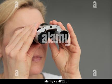 regarder à travers des jumelles sur fond noir gris avec des gens stock image photo Banque D'Images