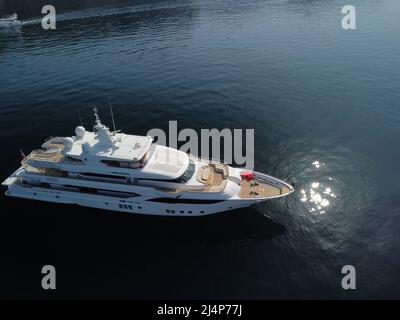 Aérien - vue de dessus en bas de la course de bateau à moteur de luxe sur l'eau grand yacht de luxe flotte dans le port de mer sur un fond de bleu sommet d'eau Banque D'Images