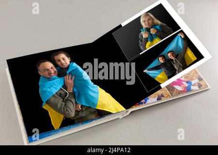 Archives photos de famille enregistrées dans un livre photo aux couleurs vives ; souvenirs d'été éclatants placés dans le livre photo. Famille avec drapeau de l'ukraine Banque D'Images