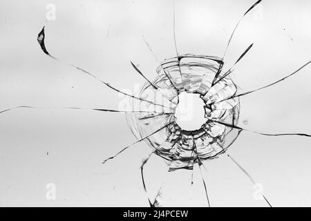 Fissures des balles dans le verre isolé sur un fond blanc Banque D'Images