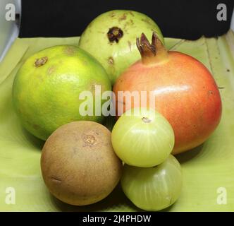 Fruits sains, lime douce (agrumes) grenade, fruit Sapodilla (chikku), groseille, fond vert Banque D'Images