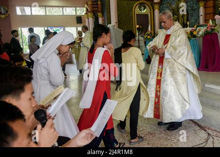 Guwahati, Inde. 17th avril 2022. Le prêtre offre la sainte communion aux fidèles chrétiens après la prière de Pâques dans une église de Guwahati, Assam, Inde, le dimanche 17 avril 2022. (Image de crédit : © David Talukdar/ZUMA Press Wire) Banque D'Images