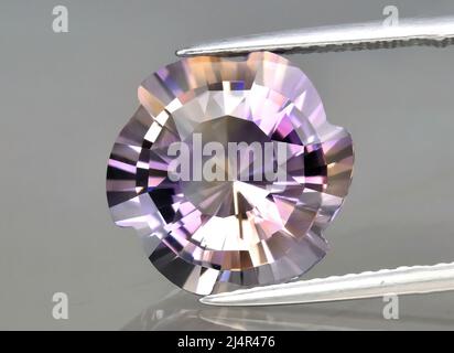 Pierre précieuse naturelle amétrine en strongs sur fond gris. Amétrine bolivienne naturelle bicolore jaune violet Banque D'Images