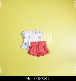 Mode bébé - ensemble chemise et short pour fille; photo sur fond jaune plat. Banque D'Images