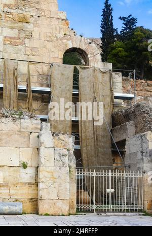 Reconstruction de l'Odéon de Herodes Atticus près de l'Acropole d'Athènes avec des andains humides et sales de tissu accrochés à l'échafaudage derrière un g de fer Banque D'Images