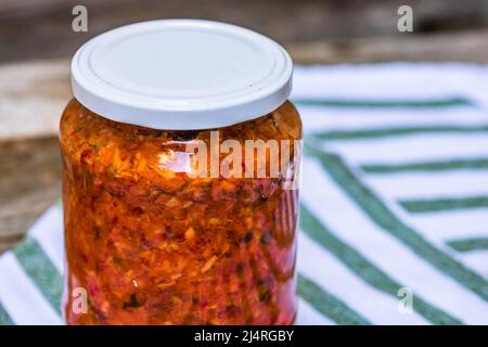 Pot en verre avec légumes en conserve. Concept de la nourriture conservée, légumes en conserve isolés dans une composition rustique. Banque D'Images