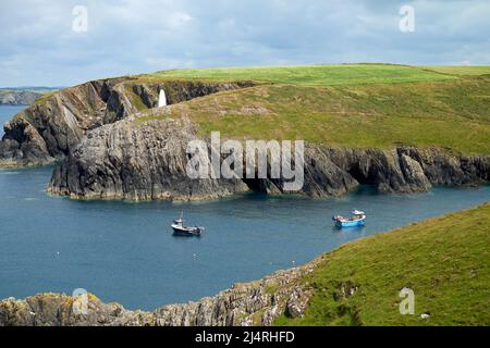 L'entrée du port de Porthgain, Pembrokeshire, pays de Galles, Royaume-Uni, avec un cairn en pierre blanchi à la chaux sur le sommet de la falaise opposée. Banque D'Images