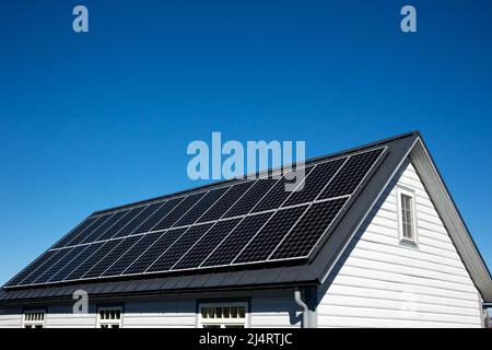 Panneaux solaires sur petit panneau de bois maison intérieure toit, concept d'énergie durable. Beaucoup d'espace de copie sur ciel bleu clair. Banque D'Images